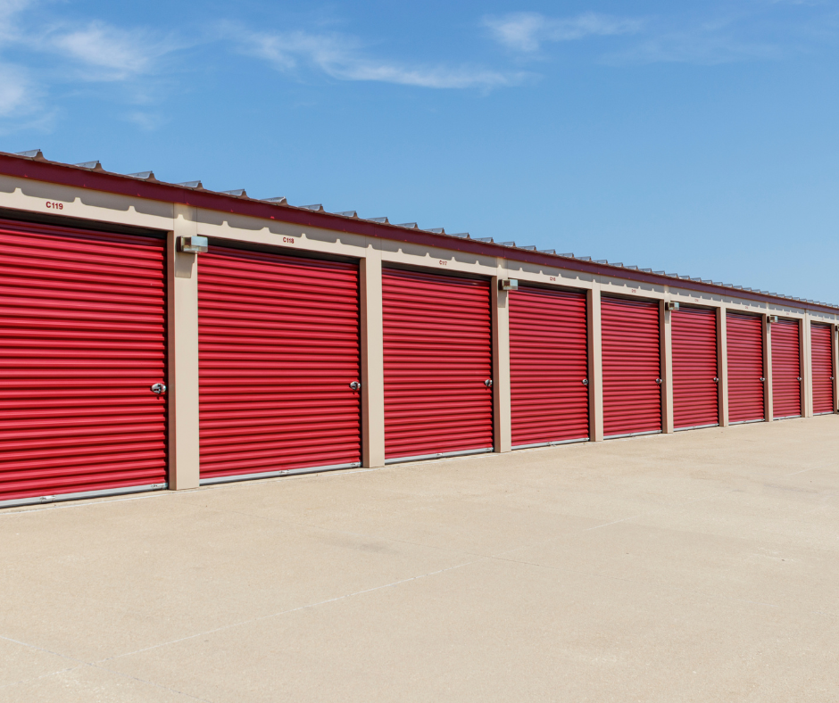 Picture of a self-storage facility with red garage doors and a blue sky overhead.