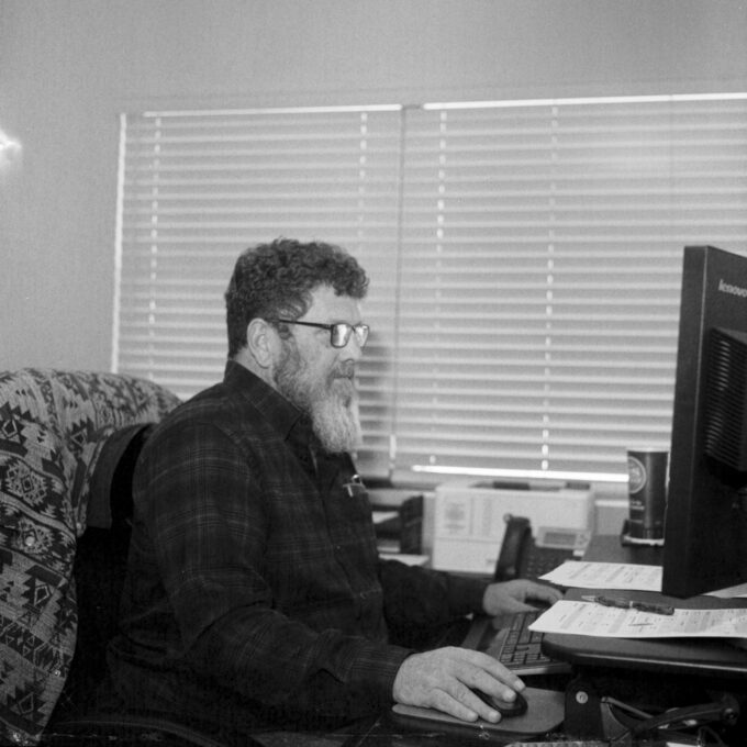 Photo of Mark Osborne of Stroud National Agency Inc. working at his desk. © 2023 Mike Garretson. All rights reserved.