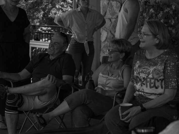 Photo of Senior Commercial Lines Underwriter Cathy Lee (front right), Irrigation Underwriter & Claims Specialist Shannon Thompson and husband Shelby (front center and left) enjoying good times at the 2023 Stroud National Agency, Inc. Summer Cookout.