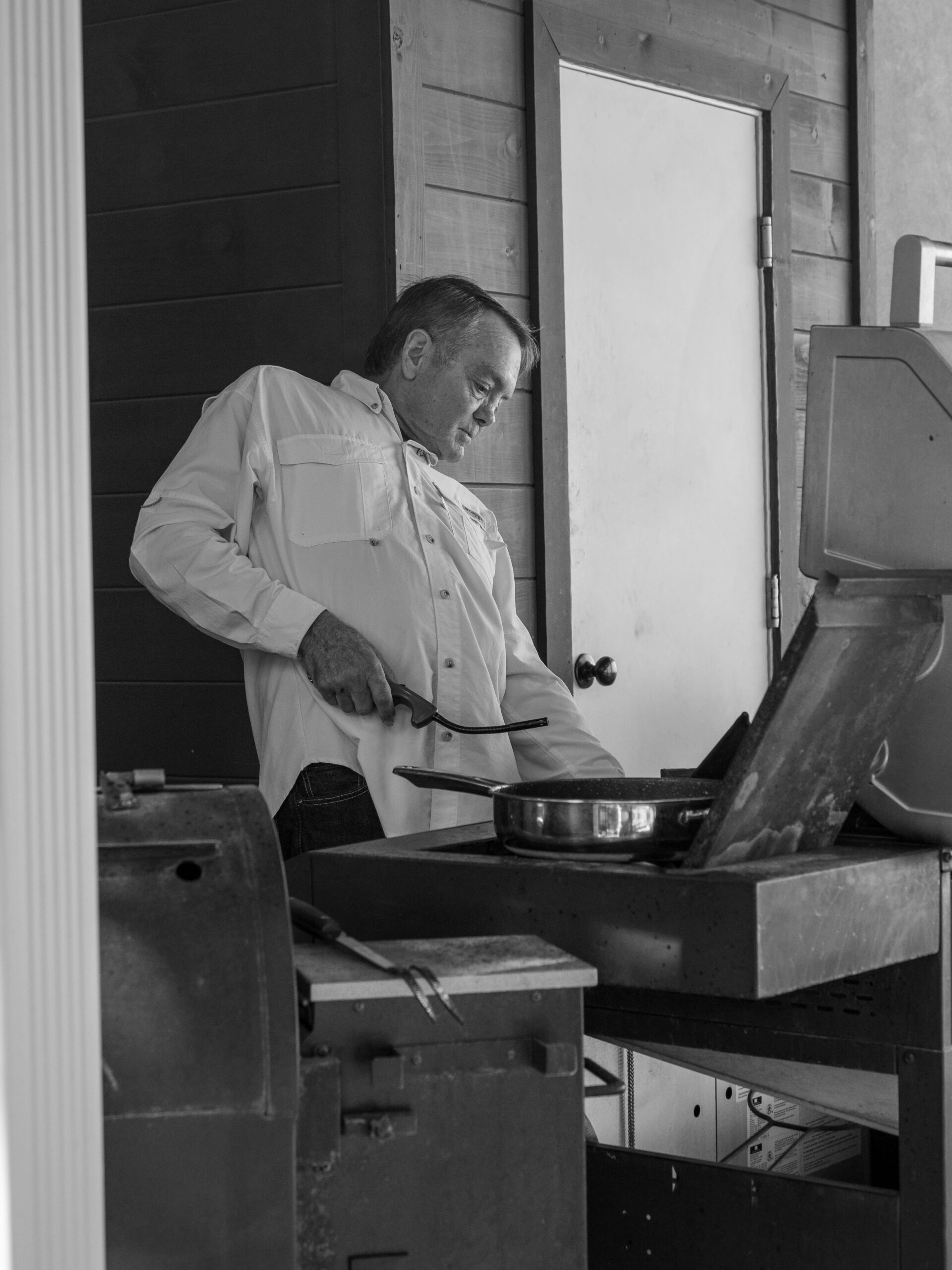 Photo of President & CEO (and resident Grillmaster) Steve B. Stroud cooking hamburgers at 2023 Stroud National Agency, Inc. Summer Cookout. © 2023 Stroud National Agency, Inc. All rights reserved.