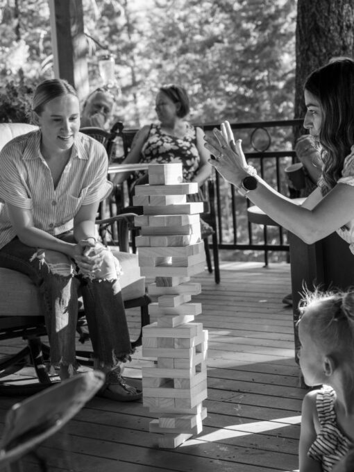 Photo of Vilma Garretson (right), wife of Communications &amp; Marketing Specialist Mike Garretson, plays Jenga while Underwriter Dawnielle Cunningham (left) looks on at the 2023 Stroud National Agency, Inc. Summer Cookout. © 2023 Stroud National Agency, Inc. All rights reserved.