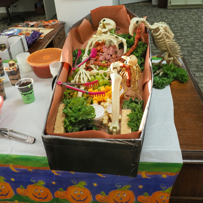 2023 Stroud National Agency, Inc. Halloween Feast - Straight view of food tray inside of a coffin with a skeleton