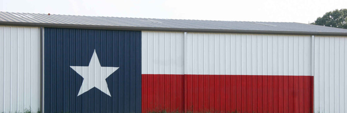 A Texas flag painted on the side of a barn.