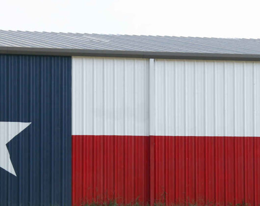A Texas flag painted on the side of a barn.