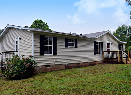 Single-story mobile home with porch and skirting, relevant to home insurance for mobile homes.