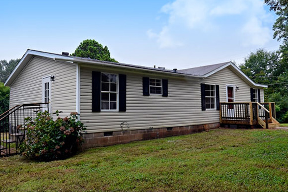 Single-story mobile home with porch and skirting, relevant to home insurance for mobile homes.